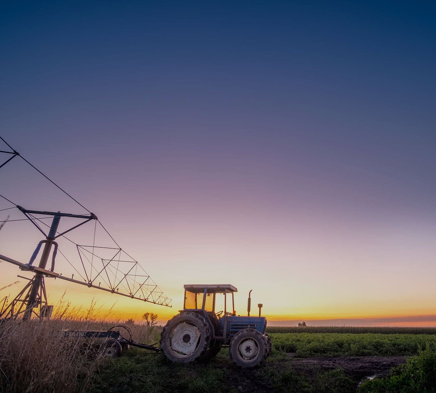 Tractor in a field at sunset