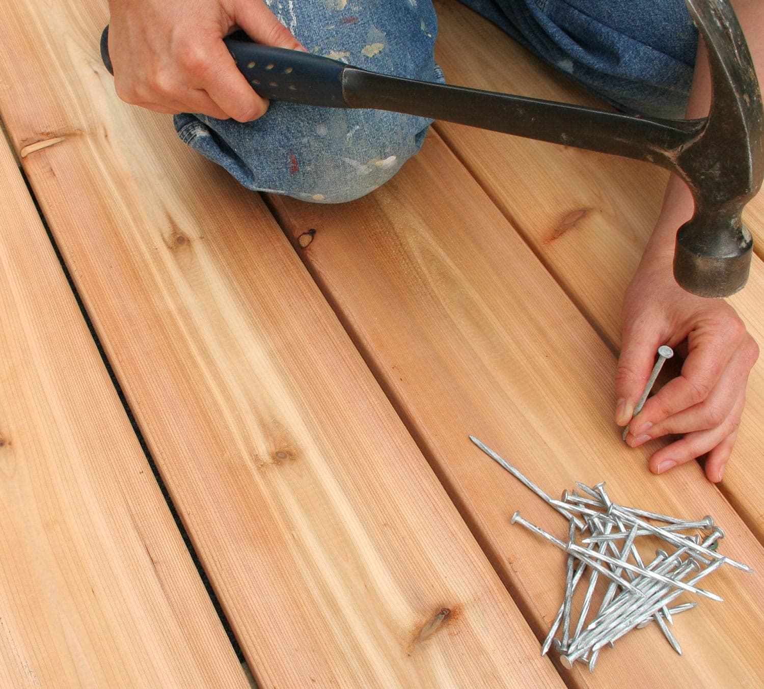 Hammering nails into timber decking