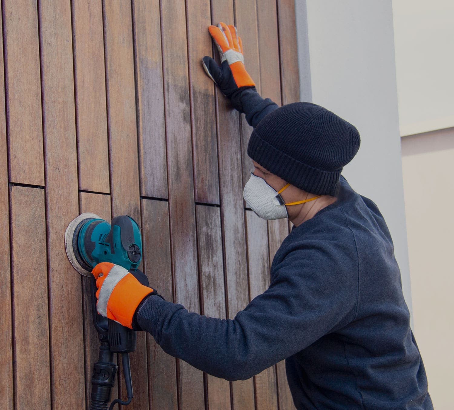 RB Thomas tradesperson sanding back timber cladding during a renovation