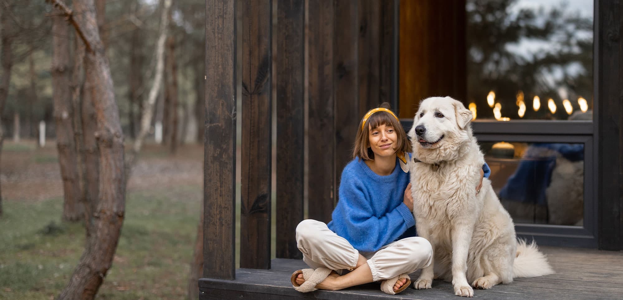 Woman and her dog relaxing by the fire in a restored home