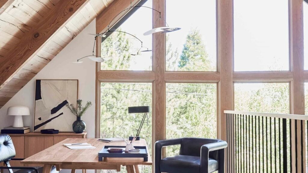 Home office in a loft with a pitched ceiling and full-height windows