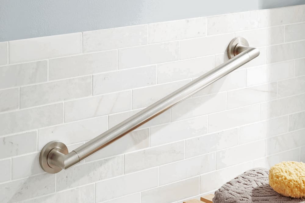 Bathroom fitted with grab bars beside the toilet and shower